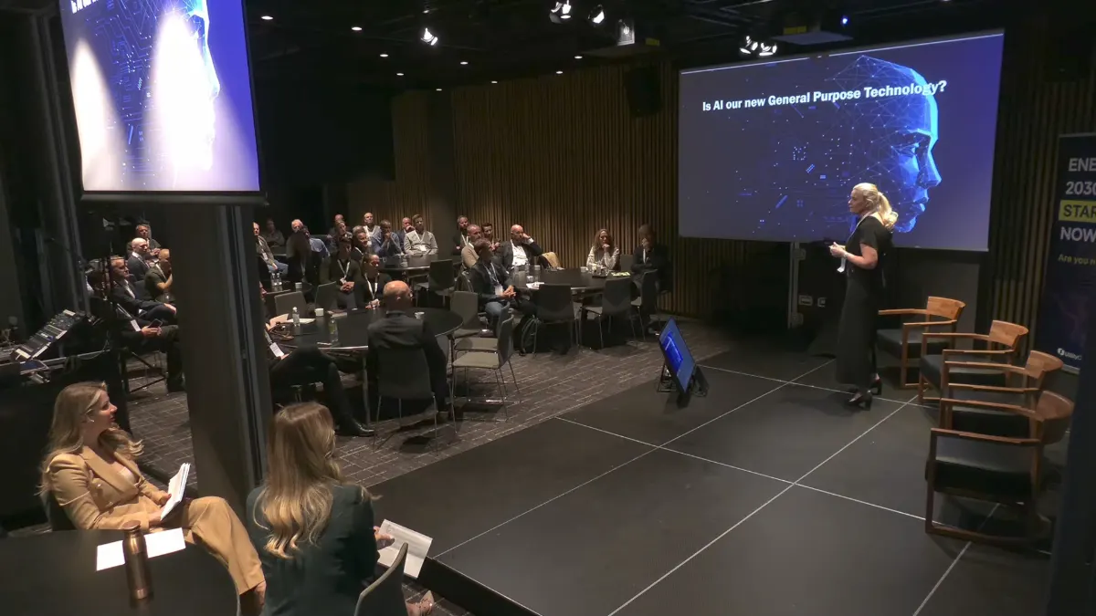 Speaker presenting slide 'Is AI our new General Purpose Technology?' to a seated audience